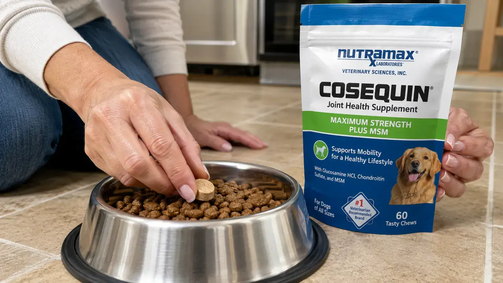 Hand sprinkling a Cosequin chewable tablet onto kibble in a stainless steel dog bowl